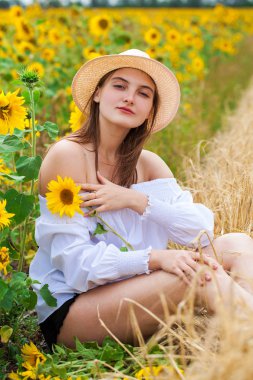 Altın bir arka plan üzerinde oturan beyaz bluz esmer kadın