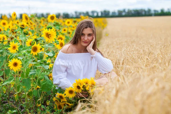 Brunett kvinna i vit blus sitter på en bakgrund av gyllene — Stockfoto