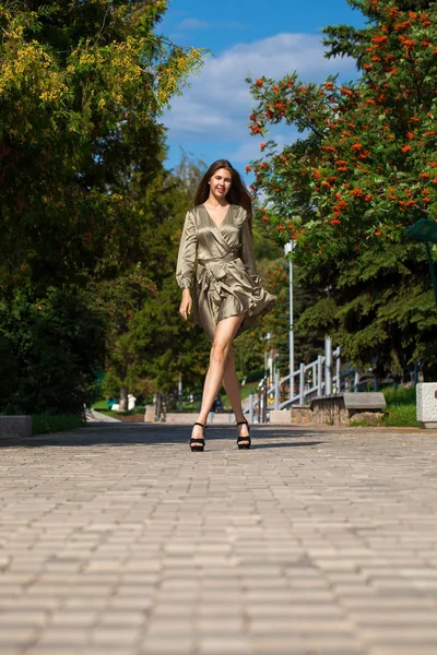 Ung vacker kvinna i grön klänning går på sommaren Stree — Stockfoto