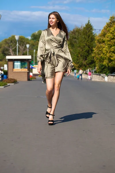 Jovem mulher bonita em vestido verde andando sobre a árvore de verão — Fotografia de Stock