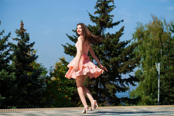Mladá krásná žena v růžových šatech chodící na letní ulici — Stock fotografie