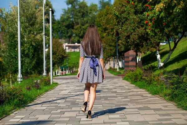 Νεαρή όμορφη γυναίκα με γκρίζο φόρεμα περπάτημα στο δρόμο του καλοκαιριού — Φωτογραφία Αρχείου