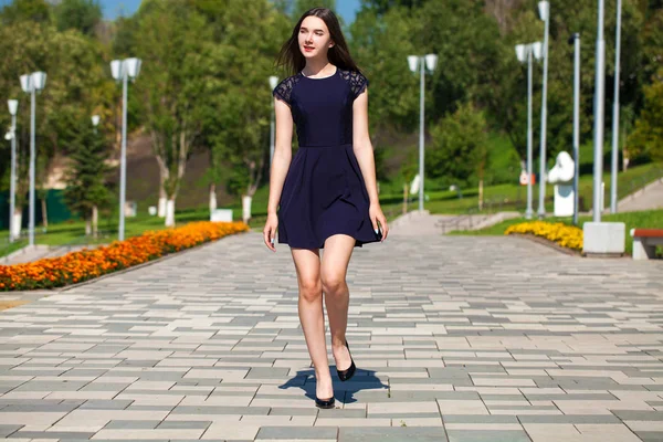 Jovem mulher bonita em vestido azul escuro andando no verão s — Fotografia de Stock