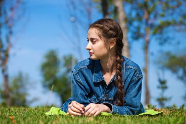 Yeşil çimenler üzerinde yatan güzel genç esmer kadın
