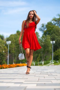 Yaz sokakta yürüyen kırmızı elbiseli genç güzel model