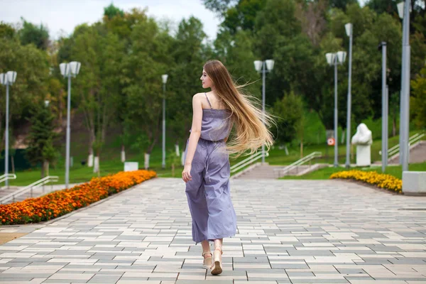 Young beautiful woman in gray dress walking on the summer street — Stock Photo, Image