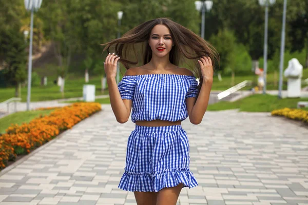 Jovem mulher bonita em vestido azul escuro andando no verão s — Fotografia de Stock