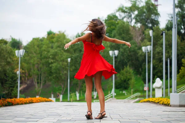 Jovem mulher bonita em vestido vermelho andando na rua de verão — Fotografia de Stock