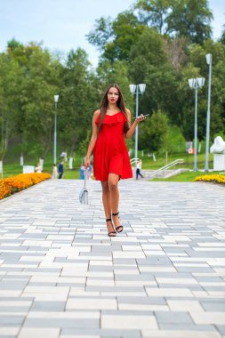 Yaz sokakta yürüyen kırmızı elbiseli genç güzel model