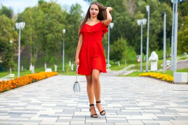 Yaz sokakta yürüyen kırmızı elbiseli genç güzel model