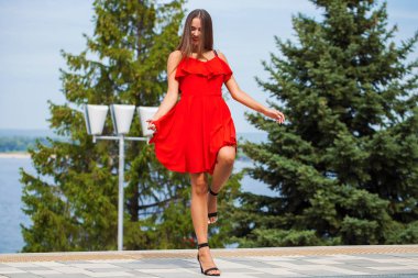 Yaz sokakta yürüyen kırmızı elbiseli genç güzel kız