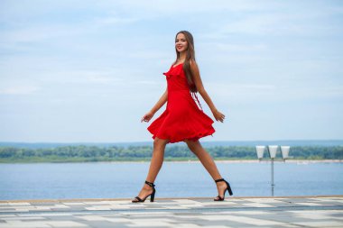 Yaz sokakta yürüyen kırmızı elbiseli genç güzel model