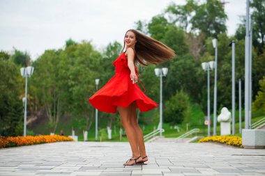 Yaz sokakta yürüyen kırmızı elbiseli genç güzel kadın