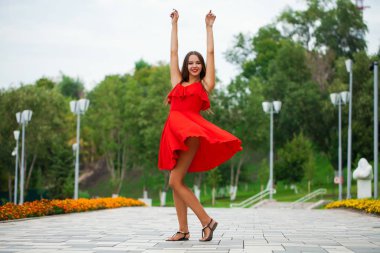 Yaz sokakta yürüyen kırmızı elbiseli genç güzel kız