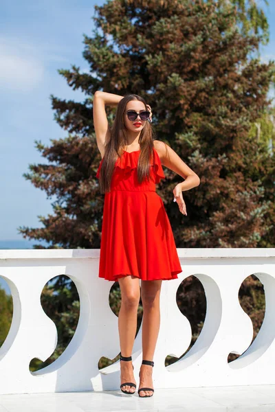 Young beautiful woman in red dress on the summer street — Stock Photo, Image