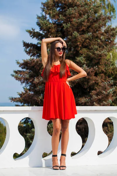 Giovane bella donna in abito rosso sulla strada estiva — Foto Stock