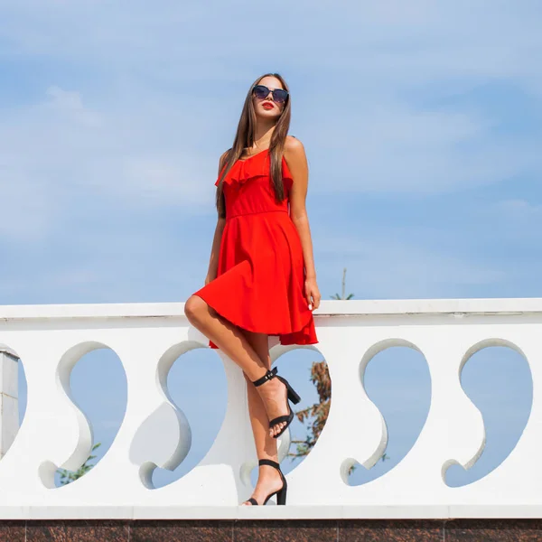 Jeune belle femme en robe rouge sur la rue d'été — Photo