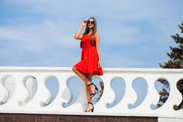 Yaz sokakta kırmızı elbiseli genç güzel kadın — Stok fotoğraf
