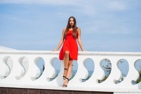 Młoda piękna kobieta w czerwonej sukni na letniej ulicy — Zdjęcie stockowe