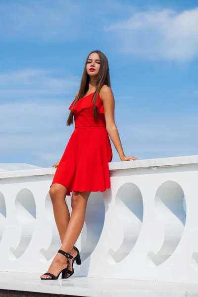 Young beautiful woman in red dress on the summer street — Stock Photo, Image