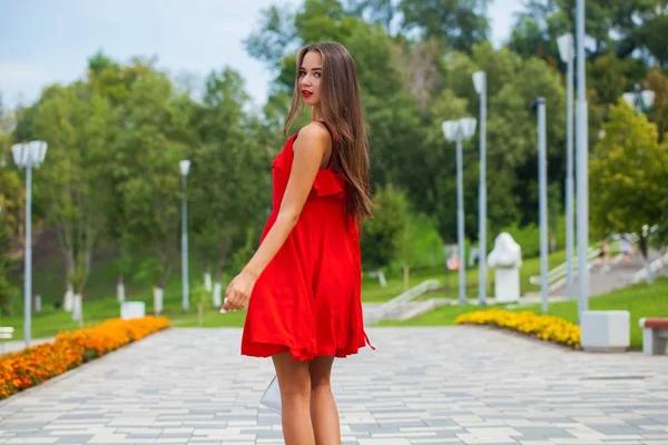 夏の通りを歩く赤いドレスを着た若い美しい少女 — ストック写真