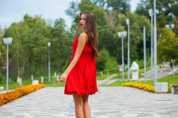 Joven hermosa chica en vestido rojo caminando en la calle de verano —  Fotos de Stock