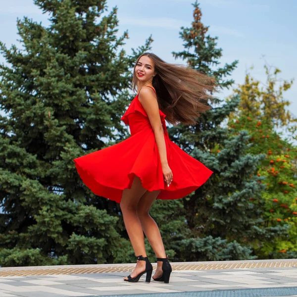 Młoda piękna dziewczyna w czerwonej sukni spaceru na letniej ulicy — Zdjęcie stockowe