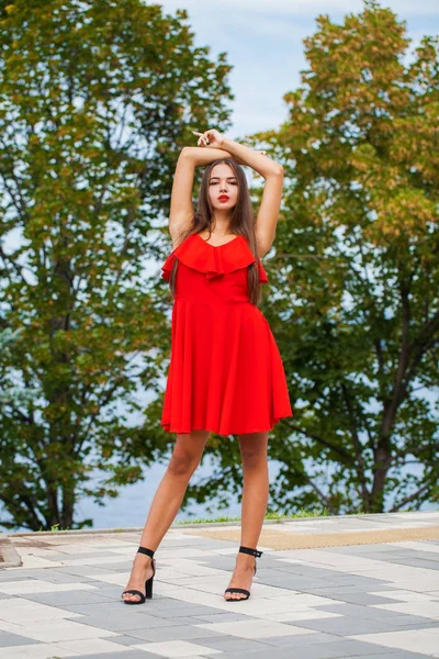 Yaz sokakta kırmızı elbiseli genç güzel kadın — Stok fotoğraf