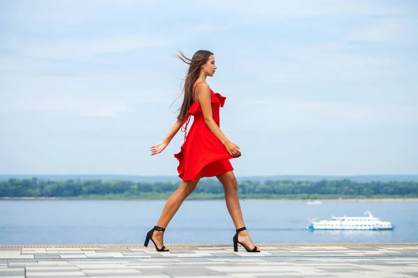 年轻的美丽模型在红色礼服走在夏天的街道 — 图库照片