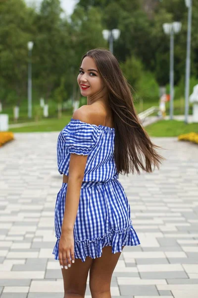 Jovem mulher bonita em vestido azul escuro andando no verão s — Fotografia de Stock