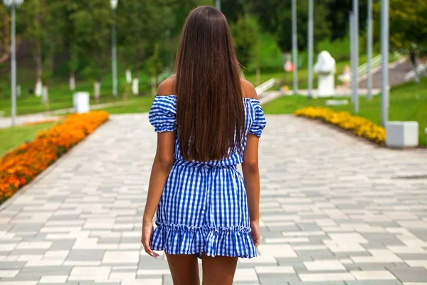 Vista trasera joven modelo morena caminando en el parque de verano, al aire libre —  Fotos de Stock