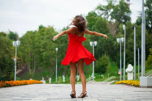 Joven hermosa mujer en vestido rojo caminando en la calle de verano — Foto de Stock