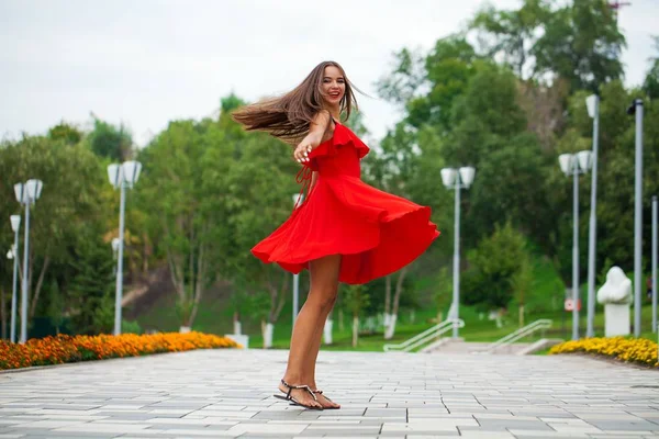 Yaz sokakta yürüyen kırmızı elbiseli genç güzel kız