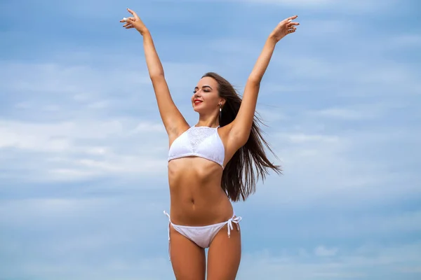 Mujer sexy en bikini blanco sobre fondo azul cielo —  Fotos de Stock