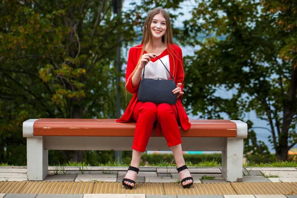Jovem mulher bonita em terno vermelho na rua de verão — Fotografia de Stock