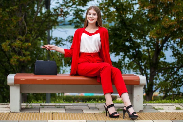 Young beautiful woman in red suit on the summer street — Stock Photo, Image