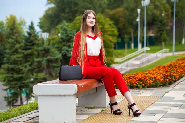 Young beautiful woman in red suit on the summer street — Stock Photo, Image