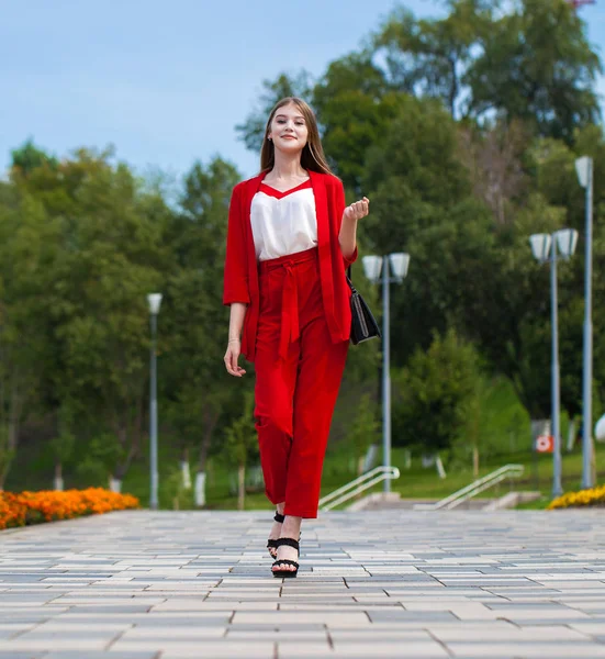 Junge schöne Frau im roten Anzug auf der Sommerstraße — Stockfoto
