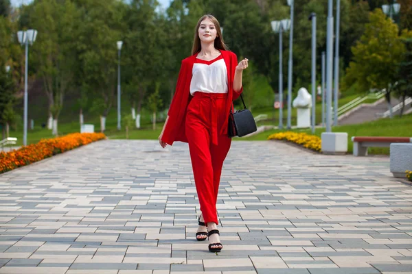 Young beautiful woman in red suit on the summer street — Stock Photo, Image