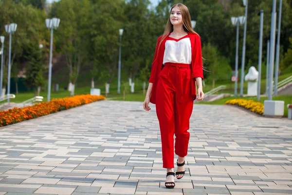 Yaz sokakta kırmızı takım elbiseli genç güzel kadın — Stok fotoğraf