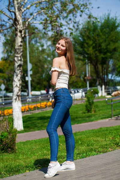 Молодая блондинка в синих джинсах и белой рубашке — стоковое фото