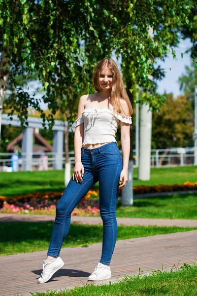 Jonge blonde zakenvrouw in blauwe jeans en wit overhemd — Stockfoto