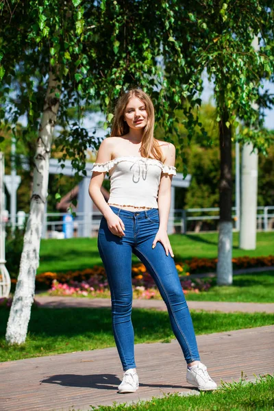 Unga blonda affärskvinna i blå jeans och vit skjorta — Stockfoto