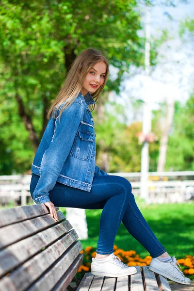 Όμορφη ξανθιά κορίτσι με ντένιμ μπουφάν και μπλε τζιν — Φωτογραφία Αρχείου