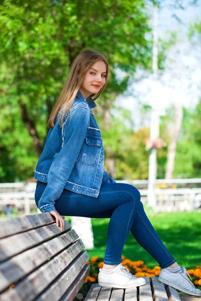 Menina loira bonita em jaqueta jeans jeans e azul — Fotografia de Stock