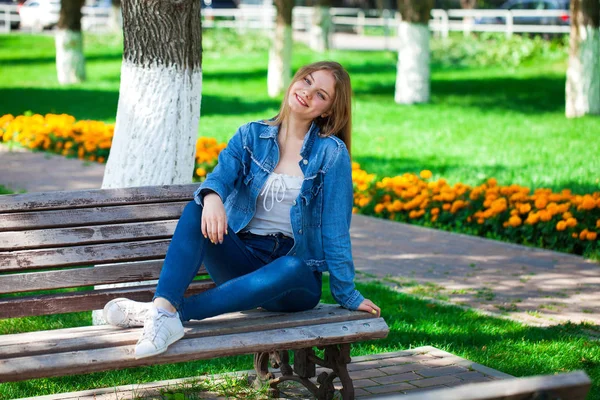 Menina loira bonita em jaqueta jeans jeans e azul — Fotografia de Stock