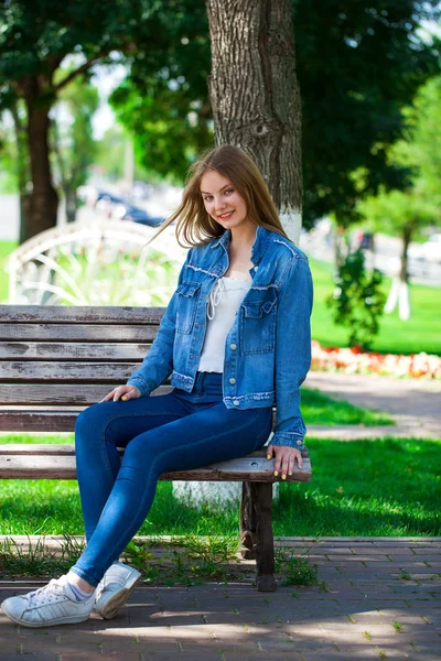 Mooi blond meisje in denim jasje en blauwe jeans — Stockfoto