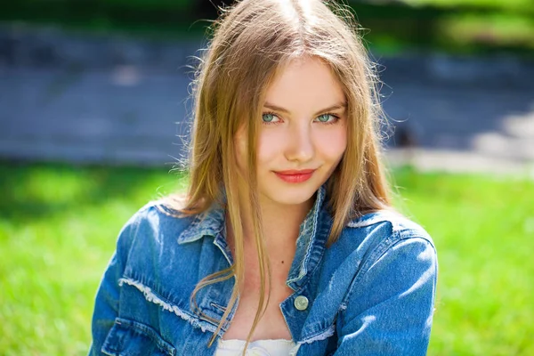 Retrato de uma jovem menina bonita em no fundo do parque de verão — Fotografia de Stock