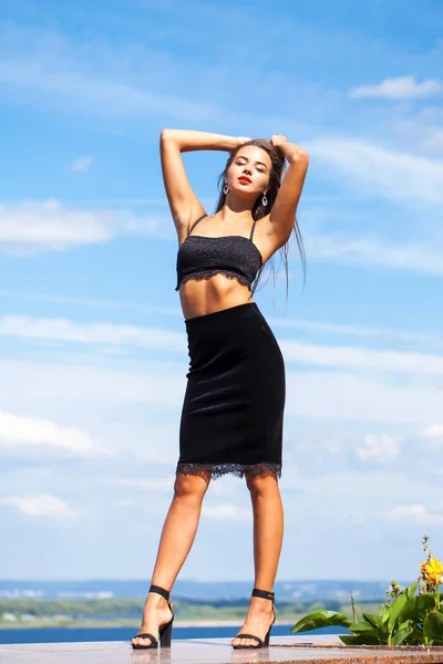 Portrait of a young beautiful girl in a black skirt and a bra po — Stock Photo, Image
