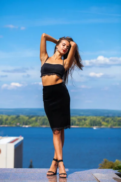 Portrait of a young beautiful girl in a black skirt and a bra po — Stock Photo, Image